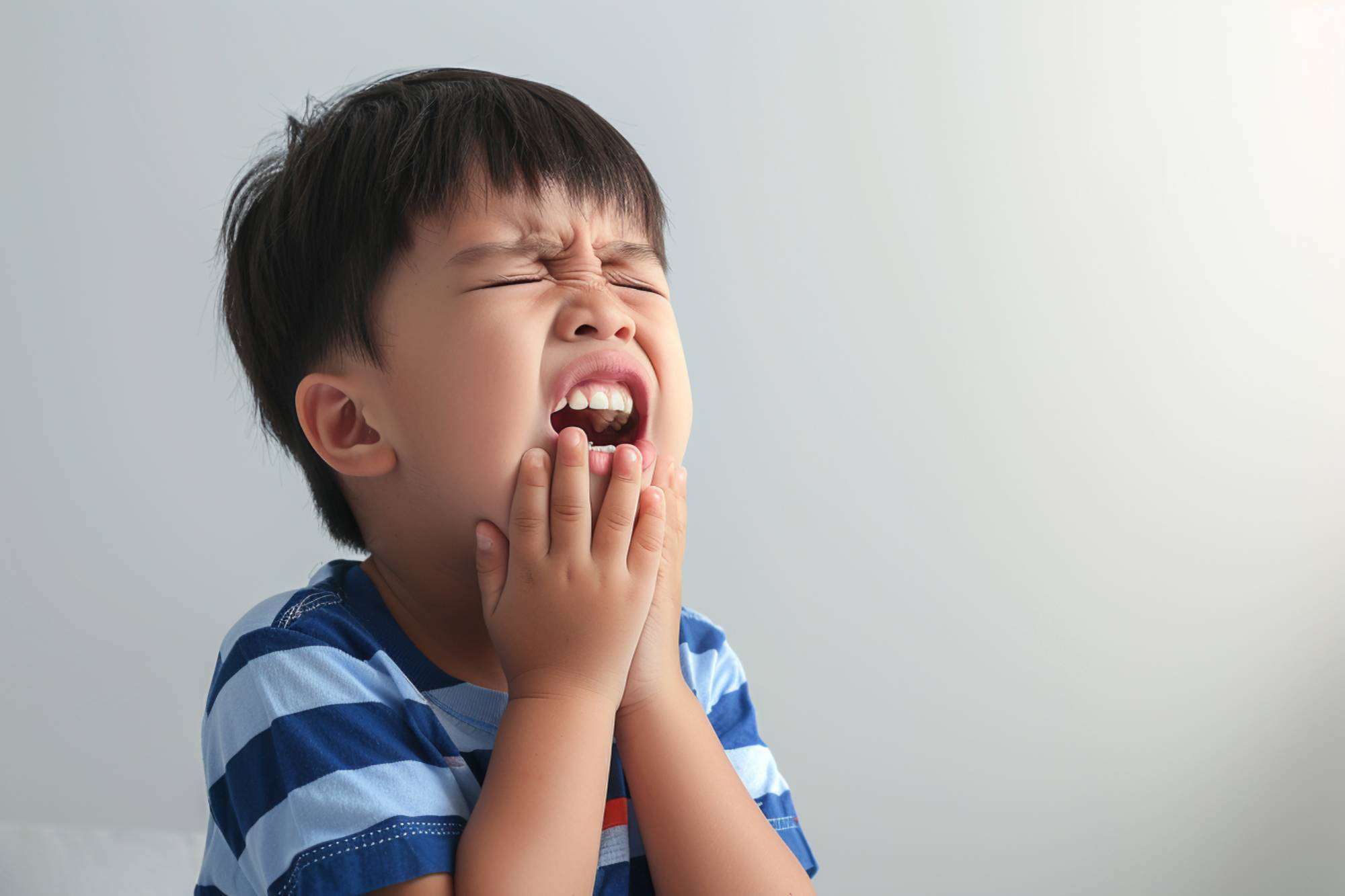 A young boy in pain due to toothache